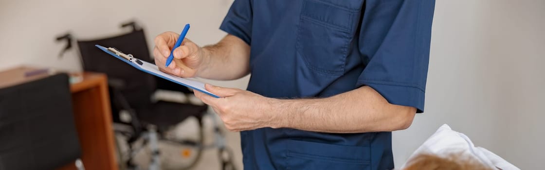 Close up of Doctor writing down patient symptoms in hospital ward during Covid-19 epidemic