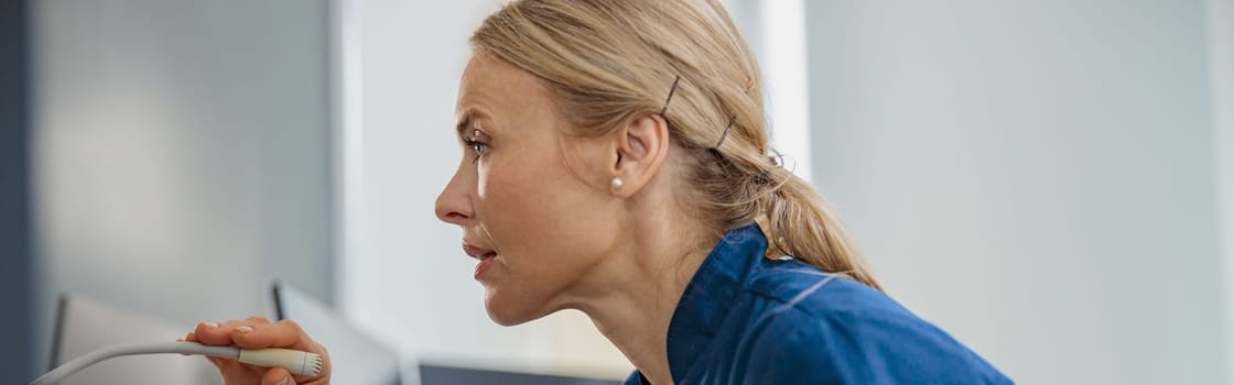 Nurse on Duty makes announcement into microphone sitting at Reception Desk. High quality photo