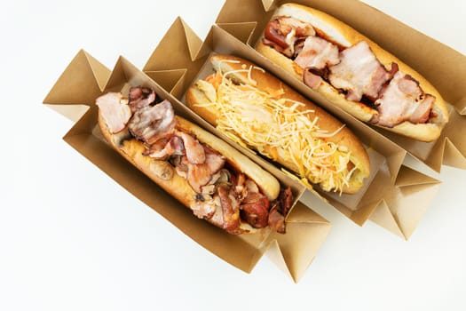 Delicious hot dog grilled in a restaurant, homemade hot dogs wrapped in bacon, with onions and mushrooms, salad. Street food, delivery, takeout, food for the car, food for travel