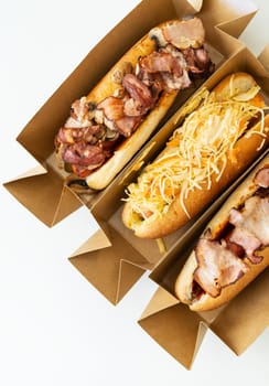 Delicious hot dog grilled in a restaurant, homemade hot dogs wrapped in bacon, with onions and mushrooms, salad. Street food, delivery, takeout