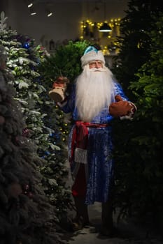 Russian Santa Claus in the store of artificial Christmas trees