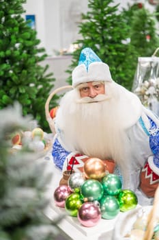 Russian santa claus holds decorations for the christmas tree in the store