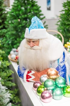Russian santa claus holds decorations for the christmas tree in the store