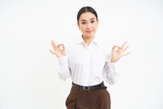 Business. Professional businesswoman, shows okay, approval gesture, recommends smth, white studio background.