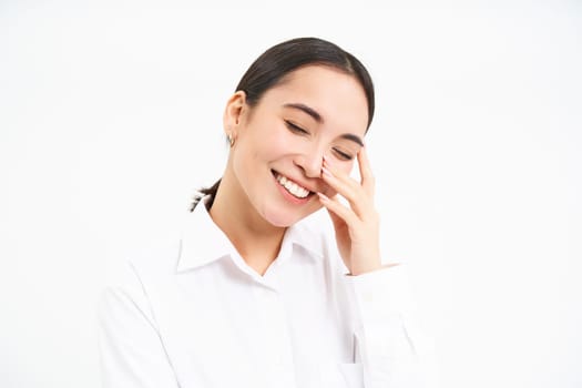 Successful women. Happy laughing asian woman smiling, looks carefree, stands over white studio background.