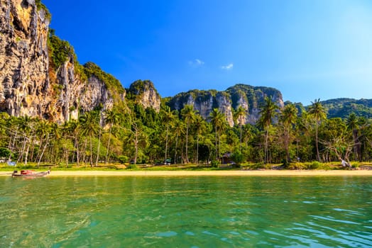 Long tail boat on tropical beach with palms, Tonsai Bay, Railay Beach, Ao Nang, Krabi, Thailand.