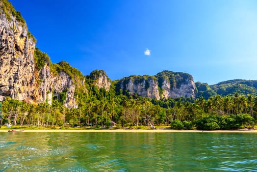 Long tail boat on tropical beach with palms, Tonsai Bay, Railay Beach, Ao Nang, Krabi, Thailand.
