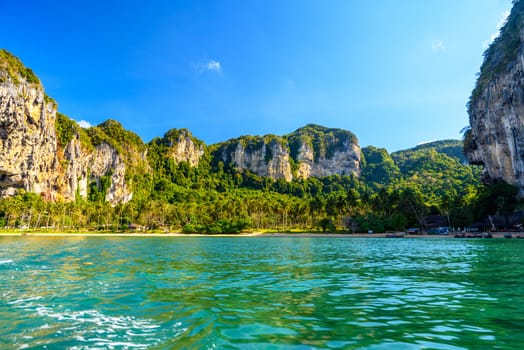 Long tail boat on tropical beach with palms, Tonsai Bay, Railay Beach, Ao Nang, Krabi, Thailand.