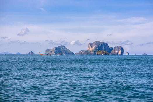 Men in long tail boats with Ko Poda and Ko Kai Chicken Island in the background, Tonsai Bay, Railay Beach, Ao Nang, Krabi, Thailand.