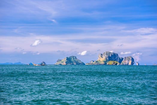 Men in long tail boats with Ko Poda and Ko Kai Chicken Island in the background, Tonsai Bay, Railay Beach, Ao Nang, Krabi, Thailand.