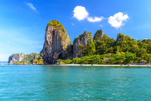 People sunbating near huge cliff rocks on Ao Phra Nang Beach, Ao Nang, Krabi, Thailand.