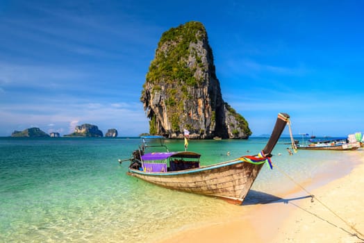 Long tail boats and cliff rock in azure water, Ko Rang Nok, Ao Phra Nang Beach, Ao Nang, Krabi, Thailand.