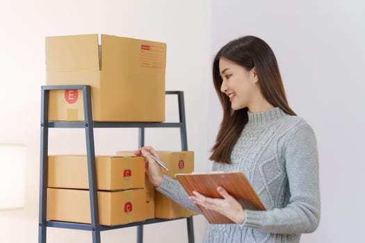 Small businesses SME owners female entrepreneurs check online orders to prepare to pack the boxes, sell to customers, sme business ideas online.