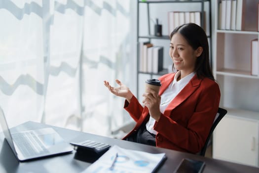 Beautiful young teen asian business woman meeting at on computer laptop with planning working on financial document, tax, exchange, accounting and Financial advisor.