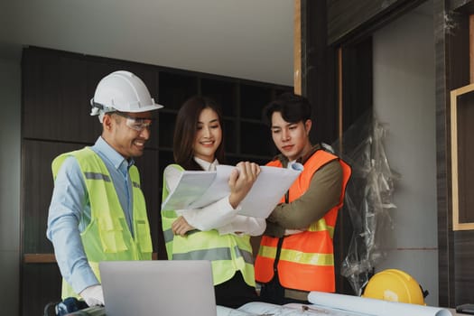 multi ethnic engineer brainstorming and measuring for cost estimating on paperworks and floor plan drawings about design architectural and engineering for houses and buildings.