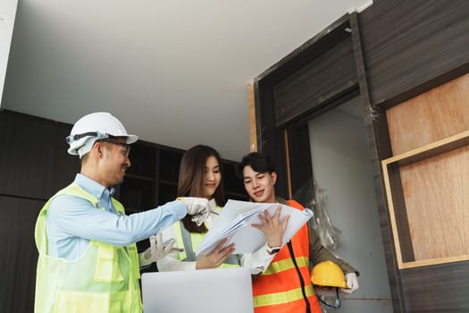 multi ethnic engineer brainstorming and measuring for cost estimating on paperworks and floor plan drawings about design architectural and engineering for houses and buildings.