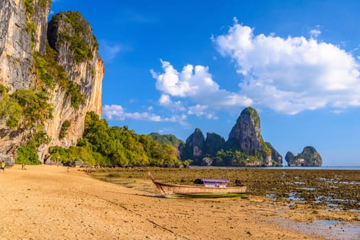 Low tide water and boats in sunset on Tonsai Bay, Railay Beach, Ao Nang, Krabi, Thailand.