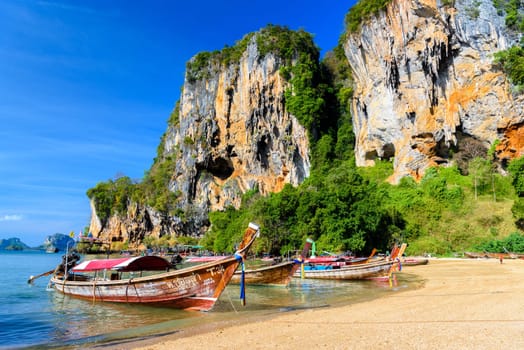 KRABI, THAILAND- MARCH 2018: Long tail boat on tropical beach with palms, Tonsai Bay, Railay Beach, Ao Nang, Krabi, Thailand.