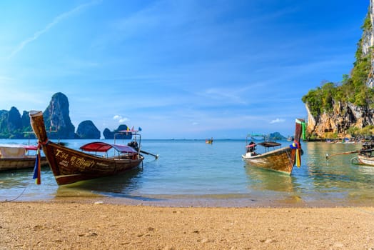 KRABI, THAILAND- MARCH 2018: Long tail boat on tropical beach with palms, Tonsai Bay, Railay Beach, Ao Nang, Krabi, Thailand.