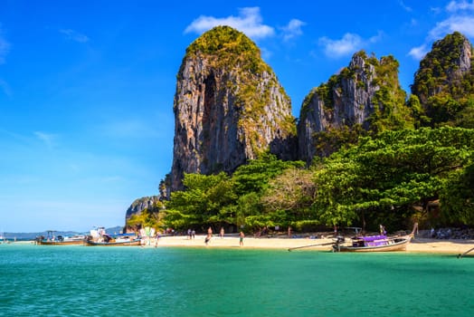 KRABI, THAILAND- MARCH 2018: People sunbating near huge cliff rocks on Ao Phra Nang Beach, Ao Nang, Krabi, Thailand.