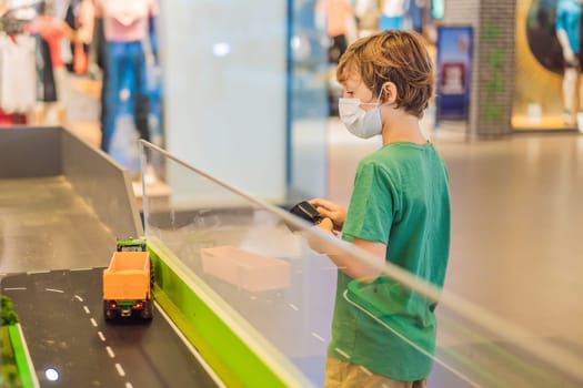 Adorable cute little child playing with toy on remote control, in the mall. Happy kid boy having fun. Leisure, lifestyle for kids concept.