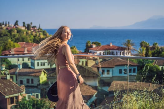 Woman tourist in Old town Kaleici in Antalya. Turkiye. Panoramic view of Antalya Old Town port, Taurus mountains and Mediterrranean Sea, Turkey.