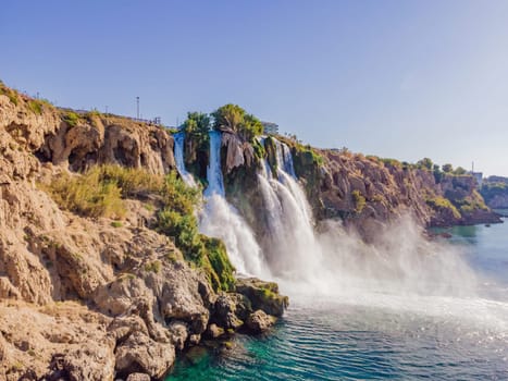 Lower Duden Falls drop off a rocky cliff falling from about 40 m into the Mediterranean Sea in amazing water clouds. Tourism and travel destination photo in Antalya, Turkey. Turkiye