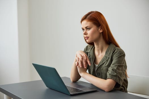 a woman sits at work at the table and looks thoughtfully, solving work issues in the office. High quality photo