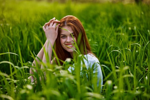 cute woman in summer high grass sits in a light dress. High quality photo