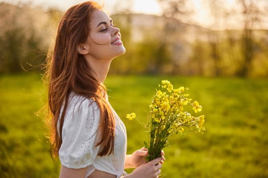 portrait of a woman with a bouquet of wild flowers in the rays of the setting sun in a field. High quality photo