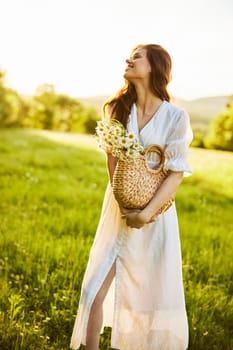 a laughing woman with a full basket of daisies stands in a light dress against the backdrop of a sunset in a field. High quality photo