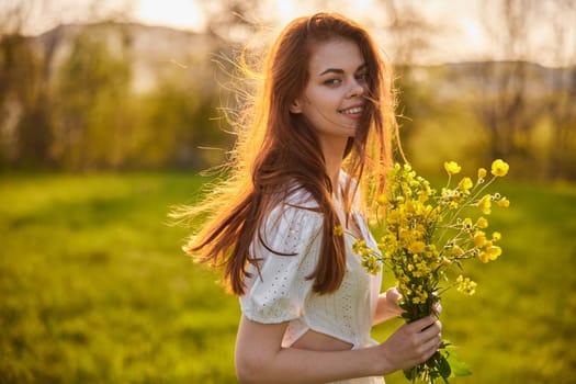 close portrait of a redhead woman smiling happily at the camera with a bouquet of yellow flowers. High quality photo