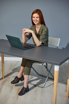 happy, joyful woman sitting at work at a laptop in the office. Work, technology. High quality photo