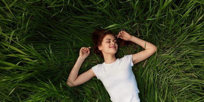 happy woman lies in green grass field. High quality photo