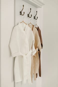 Linen bathrobes hang on a hanger in the bathroom.