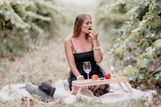 Picnic and wine tasting at sunset in the hills of Italy, Tuscany. Vineyards and open nature in the summer. Romantic dinner, fruit and wine.