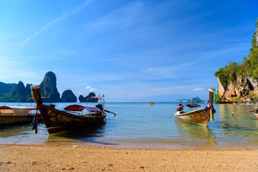 KRABI, THAILAND- MARCH 2018: Long tail boat on tropical beach with palms, Tonsai Bay, Railay Beach, Ao Nang, Krabi, Thailand.