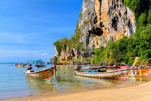 KRABI, THAILAND- MARCH 2018: Long tail boat on tropical beach with palms, Tonsai Bay, Railay Beach, Ao Nang, Krabi, Thailand.