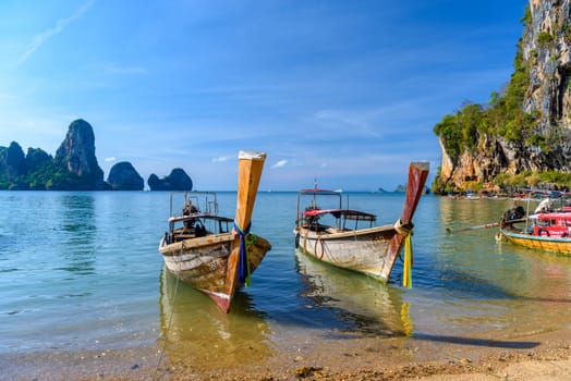 KRABI, THAILAND- MARCH 2018: Long tail boat on tropical beach with palms, Tonsai Bay, Railay Beach, Ao Nang, Krabi, Thailand.