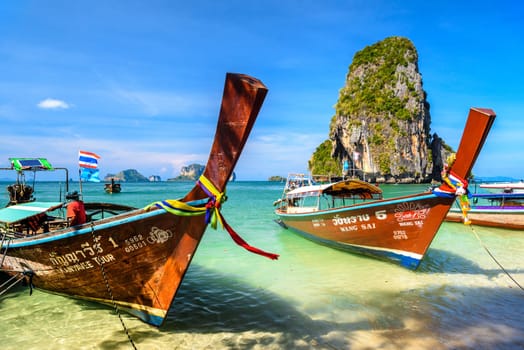 KRABI, THAILAND- MARCH 2018: Long tail boats and cliff rock in azure water, Ko Rang Nok, Ao Phra Nang Beach, Ao Nang, Krabi, Thailand.