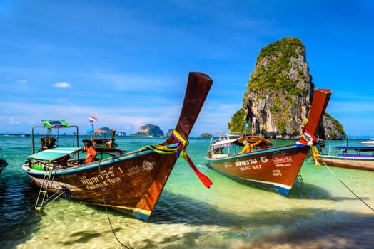 KRABI, THAILAND- MARCH 2018: Long tail boats and cliff rock in azure water, Ko Rang Nok, Ao Phra Nang Beach, Ao Nang, Krabi, Thailand.