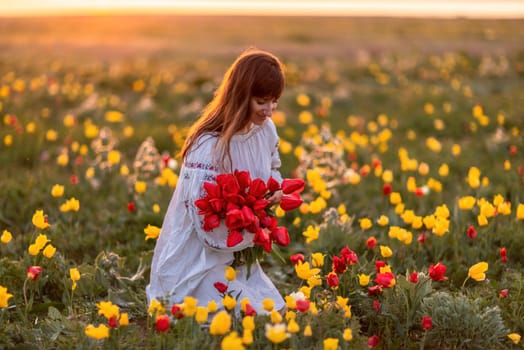 Woman field tulips sunset. Woman against sunset and wild tulip flowers, natural seasonal background. Multi-colored tulips Tulipa schrenkii in their natural habitat are listed in the Red Book