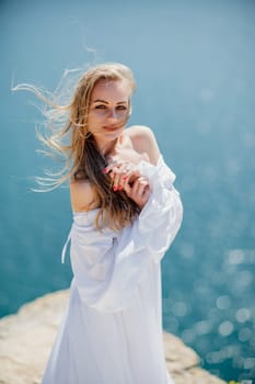 Portrait of a blond woman at the sea, a woman makes photos for memory from a trip to the sea to show to friends