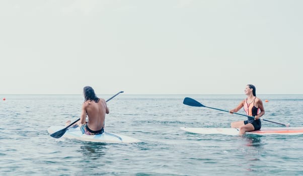 Woman sup yoga. Happy young sporty woman practising yoga pilates on paddle sup surfboard. Female stretching doing workout on sea water. Modern individual female outdoor summer sport activity