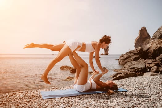 Woman sea yoga. Back view of free calm happy satisfied woman with long hair standing on top rock with yoga position against of sky by the sea. Healthy lifestyle outdoors in nature, fitness concept.