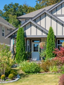 Entrance of beautiful family house with landscaped front yard in suburban area of Vancouver, Canada