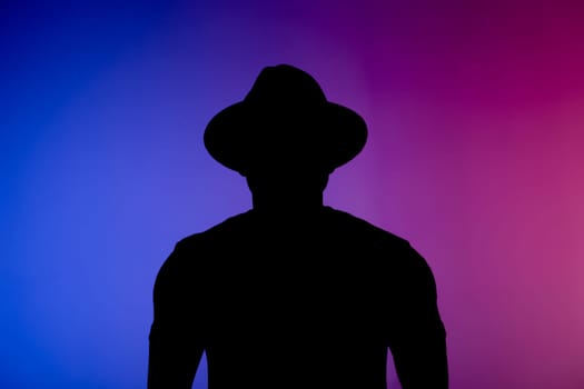 Silhouette head of sad african american man in hat on colourful neon isolated background with copy space