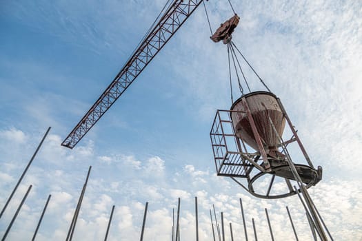 A low angle shot of a crane with equipment on a construction site near a new building infrastructure