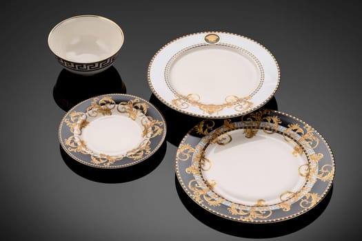 A luxury tableware set on black reflective surface