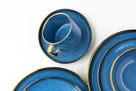 A set of blue ceramic plates and cup on a white background